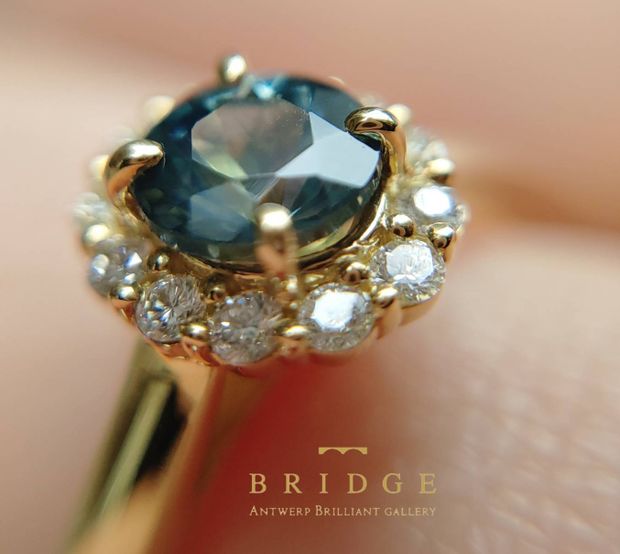 【BRIDGE ANTWERP BRILLIANT GALLERY(ブリッジ・アントワープ・ブリリアント・ギャラリー)】モンタナサファイアを使用したダイヤモンドヘイローリングSunflower