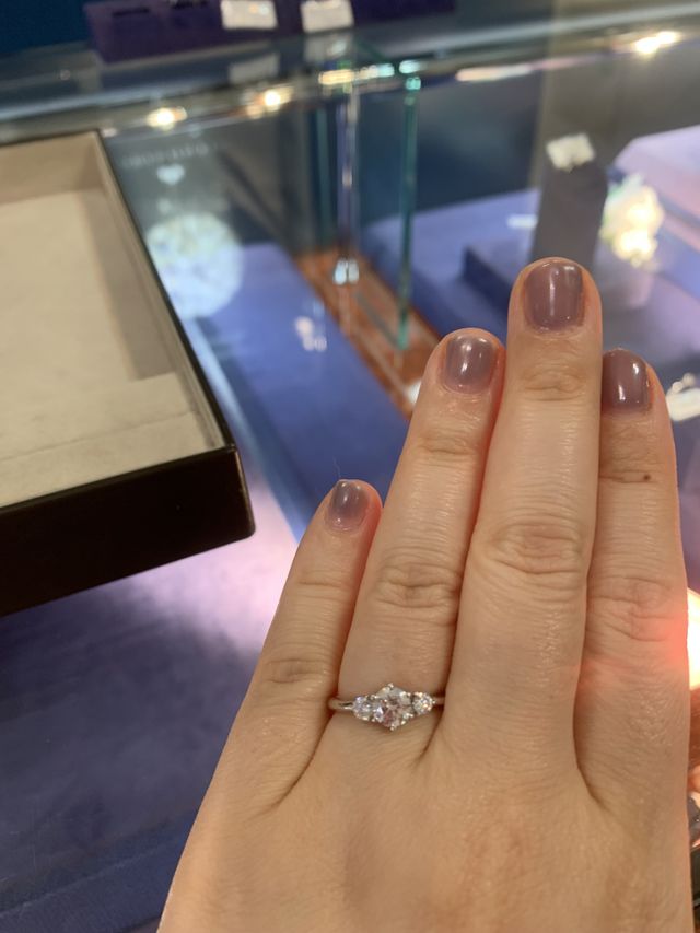 正面のダイヤを両脇の石が引き立てます。