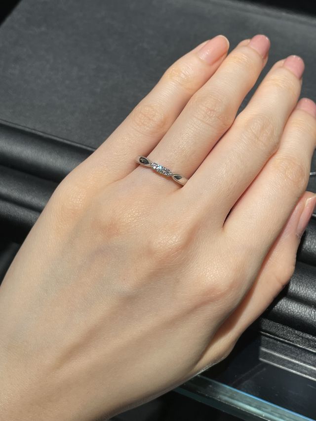 中央の3連ダイヤとミル打ちされたリボン形リングで華やか