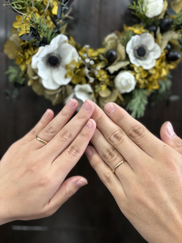 お花をバックに、2人で結婚指輪をつけて撮った写真です。