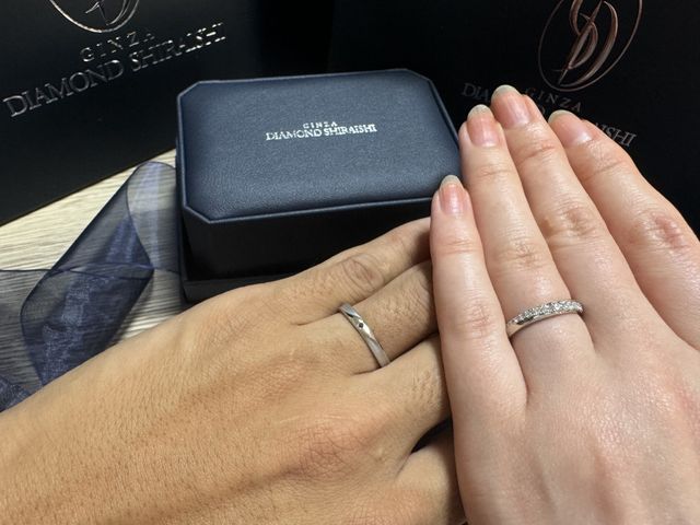 2人がリングをつけて手を重ねている写真