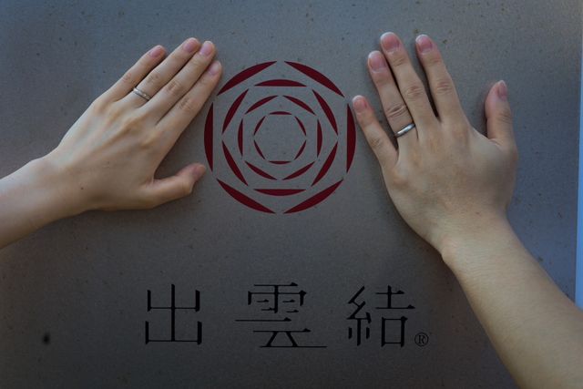 お店の看板の前で