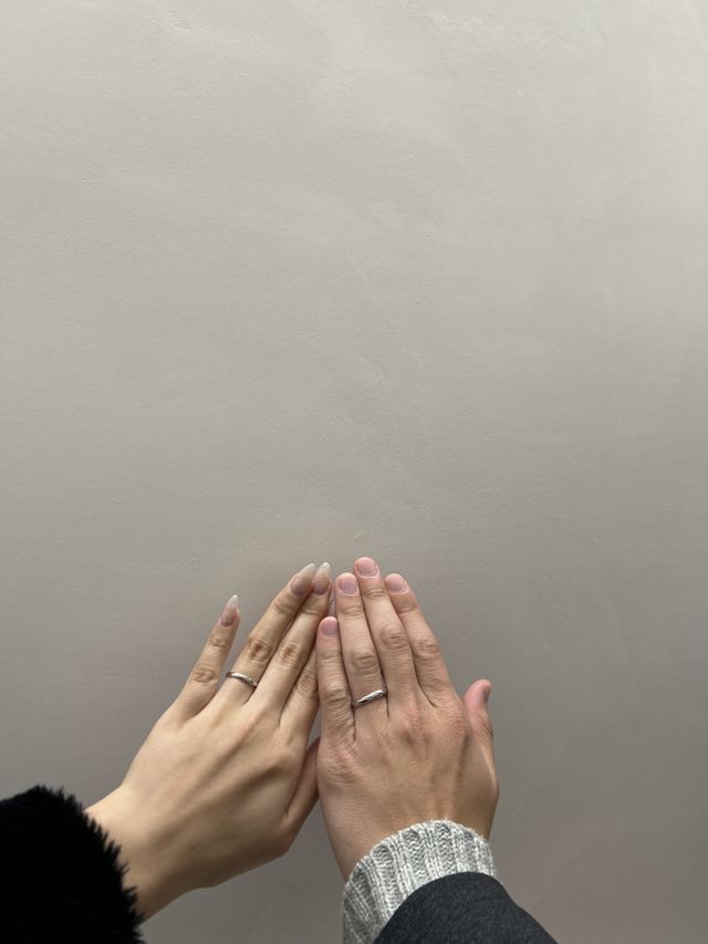 2人が手をかざして結婚指輪を撮る様子
