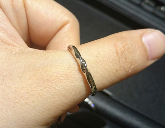 新郎結婚指輪店頭試着時の写真です。新婦の指にはめてます。