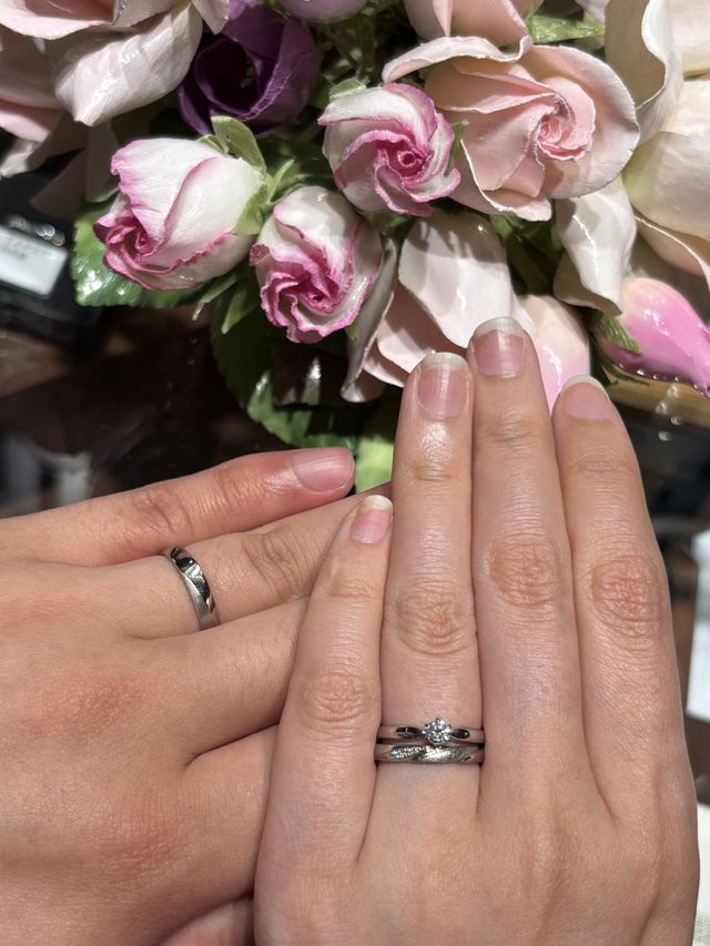 別ブランドの婚約指輪と重ねて結婚指輪を着けている。(下)