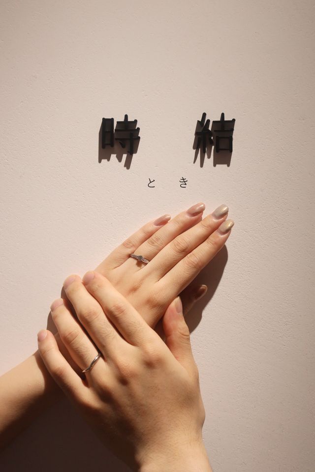 時結のロゴの前で