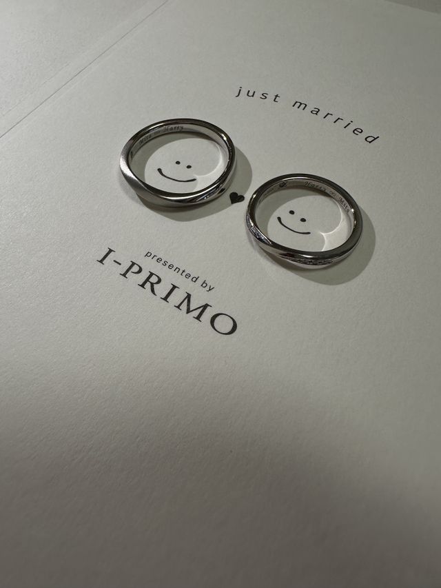 ポストカードのニコちゃんマークに二人の指輪が可愛く映っている