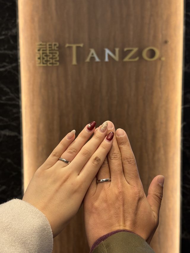 お店のロゴの前で