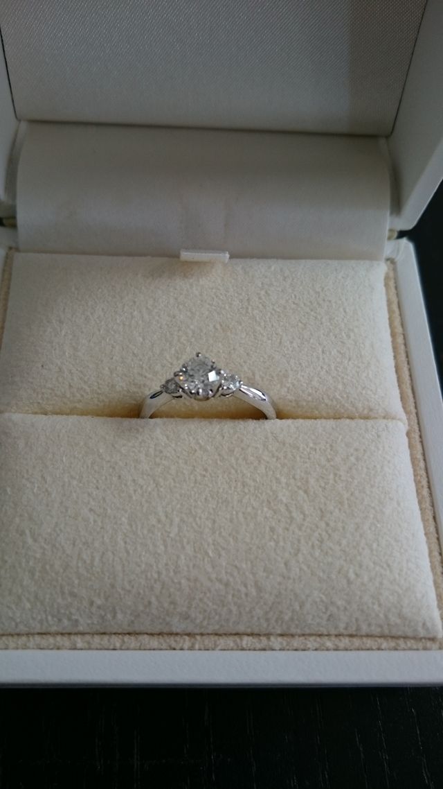 中心のダイヤを引き立てる二粒のダイヤ