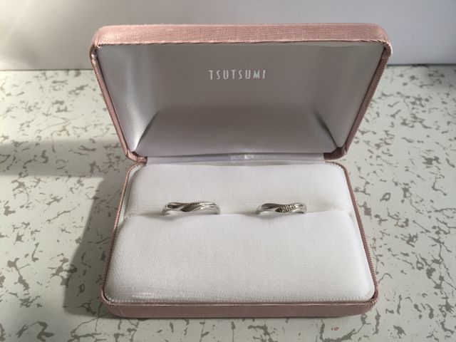 女性の指輪には真ん中に3つの小さなダイヤモンドがあります。