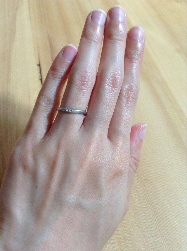 ウェーブのあるプラチナの指輪に小さいダイヤが３粒ついています