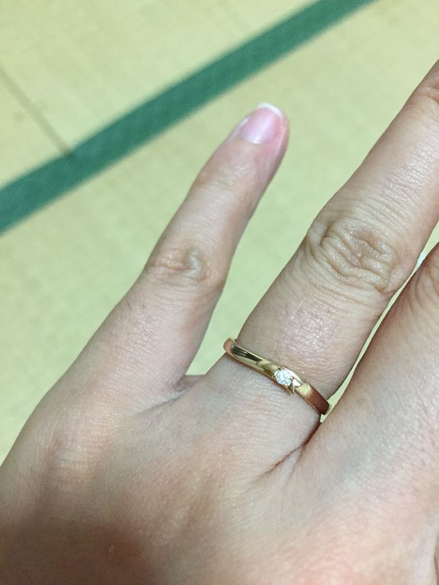 ピンクゴールドのリング、リボンモチーフ、真ん中にダイヤが一粒