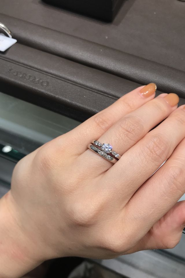 サイドにメレダイヤがついた婚約指輪と新作の結婚指輪の重ね付け