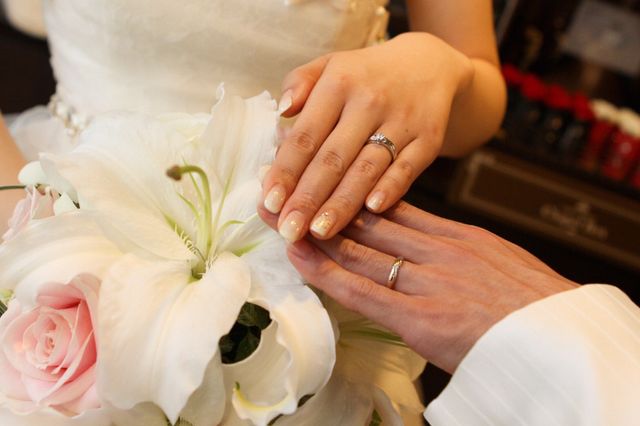 結婚式後に撮影。婚約指輪との重ね付けをしている。