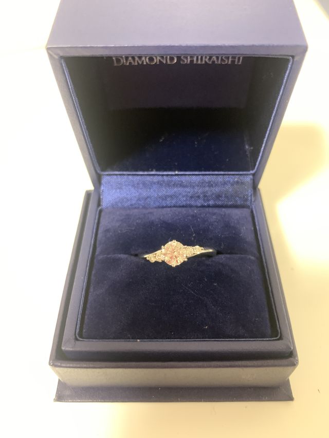 婚約指輪。ダイヤの両脇にそれぞれ二つの小さなダイヤがある。