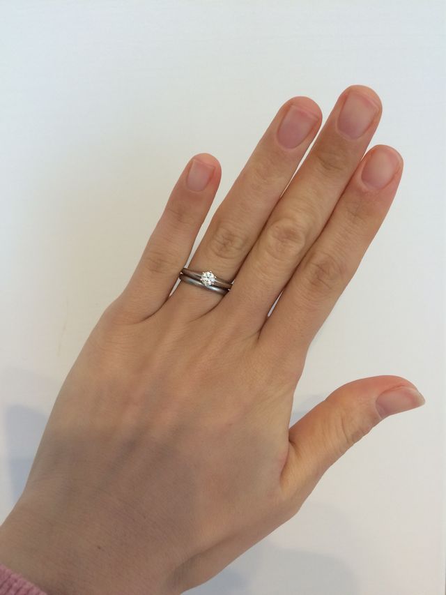 ティファニーの結婚指輪と婚約指輪を重ねづけしている写真です。