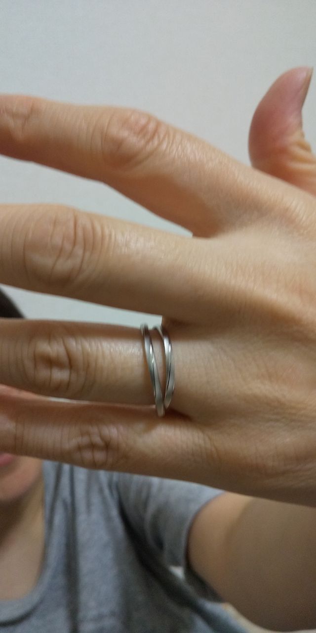 右手の薬指にペアで指輪をはめた画像です