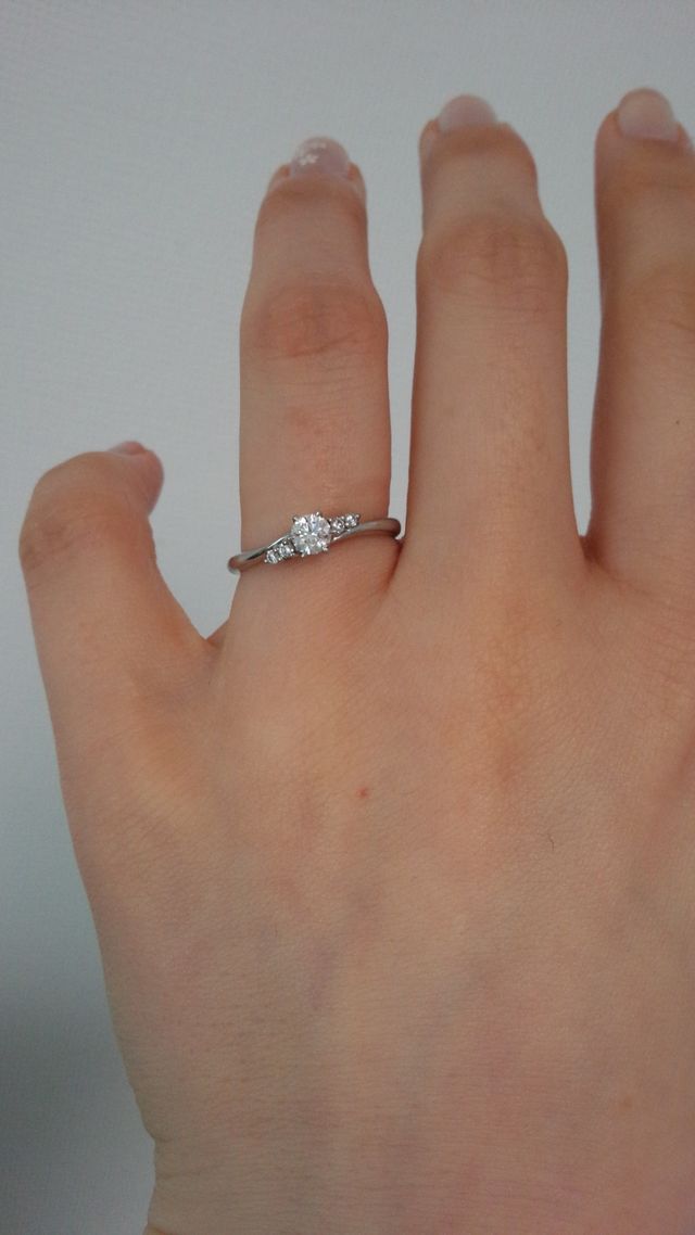 サイドにメレダイヤの付いた曲線状の指輪です