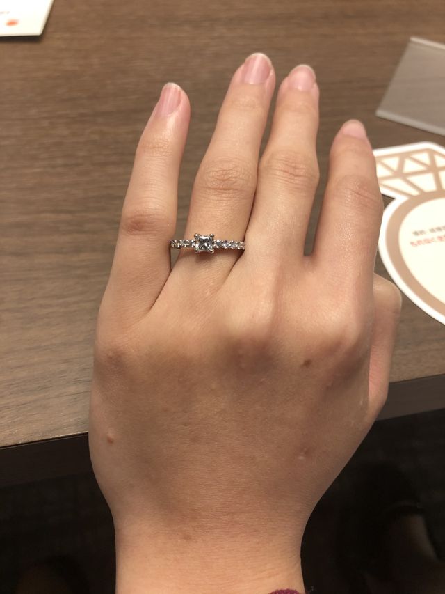 プリンセスカットダイヤを中心に置いたパブェタイプの婚約指輪