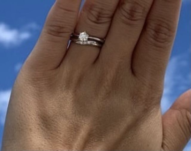 大粒ダイヤがついた婚約指輪をつけています。