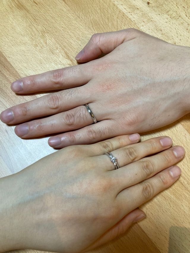 新郎と新婦の手に結婚指輪及び婚約指輪を装着している写真