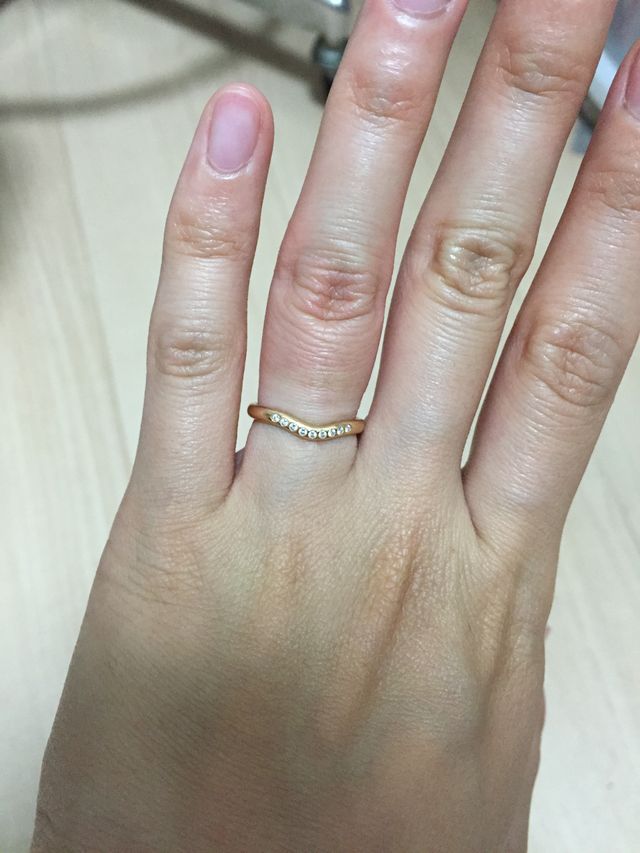 小ぶりのダイヤモンドが9個ついているゴールドの指輪。