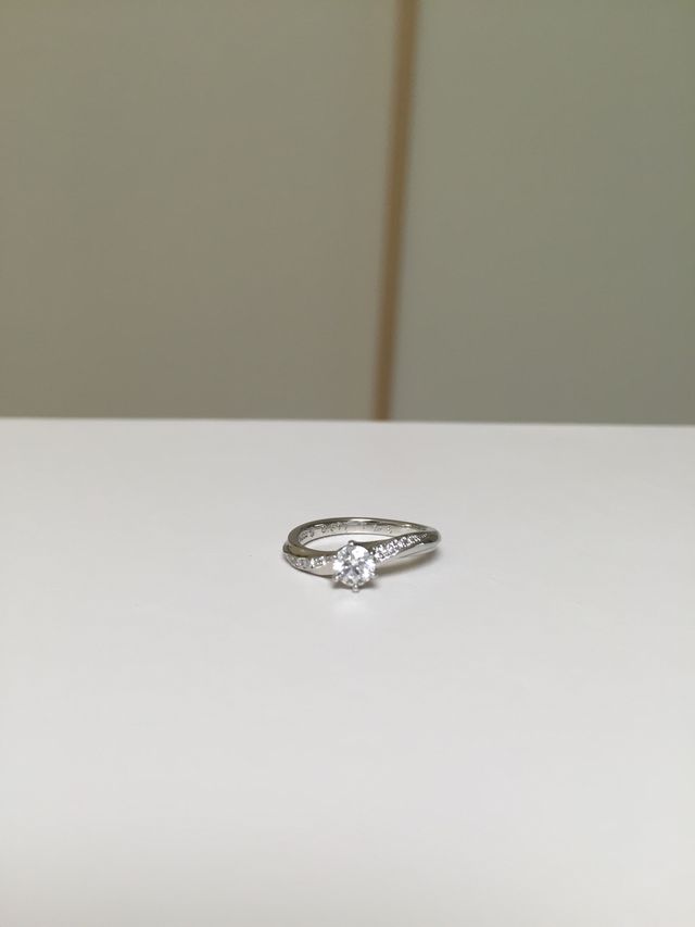 婚約指輪。主役のダイヤモンドの両サイドに小さなダイヤが。