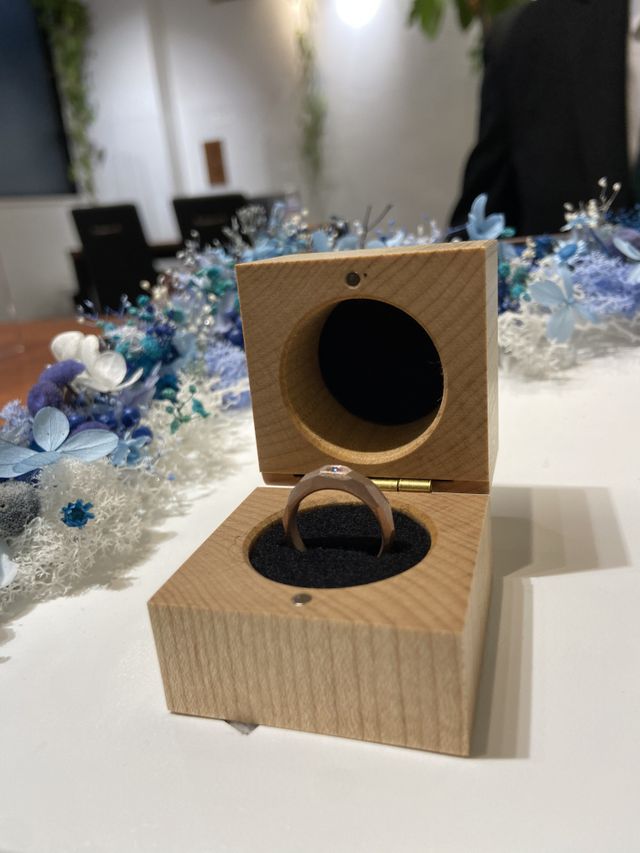 スクエア型の木箱に入ったピンクゴールドの槌目デザイン