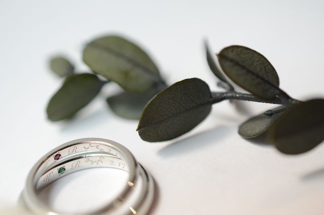 お互いの誕生石、イニシャル、記念日、月桂樹を刻印しました