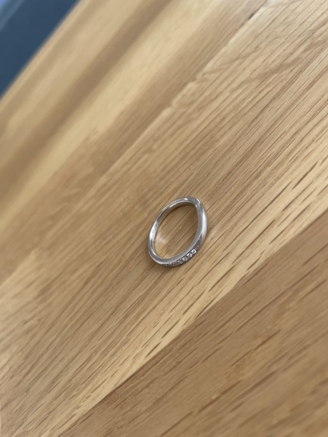 左側1/4にダイヤが７粒埋め込まれた細身のリングです。