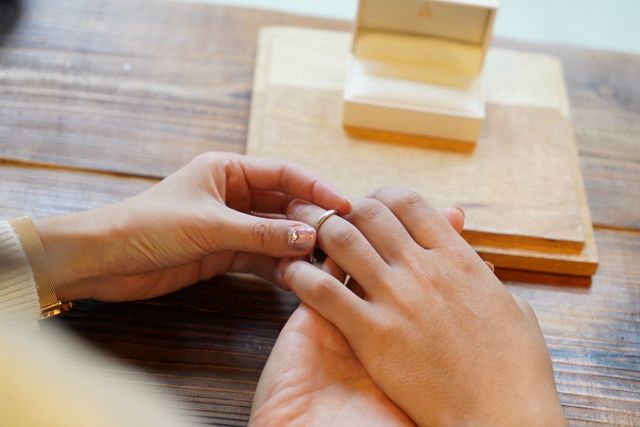 互いの指に指輪を通す瞬間の写真です。