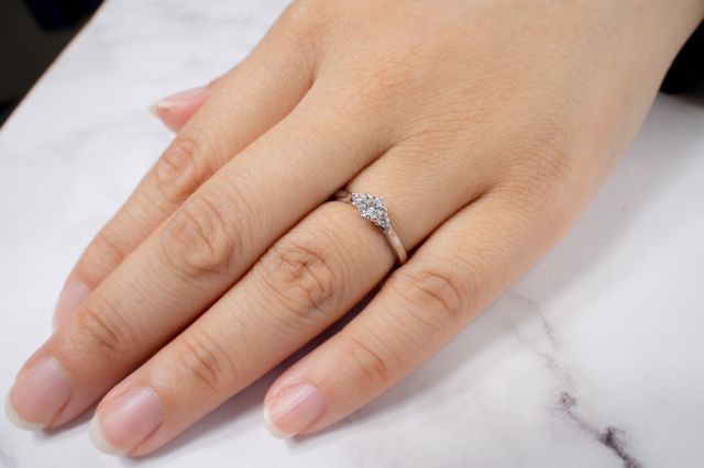 中央に大きなダイヤ、脇に2つメレダイヤのデザイン。