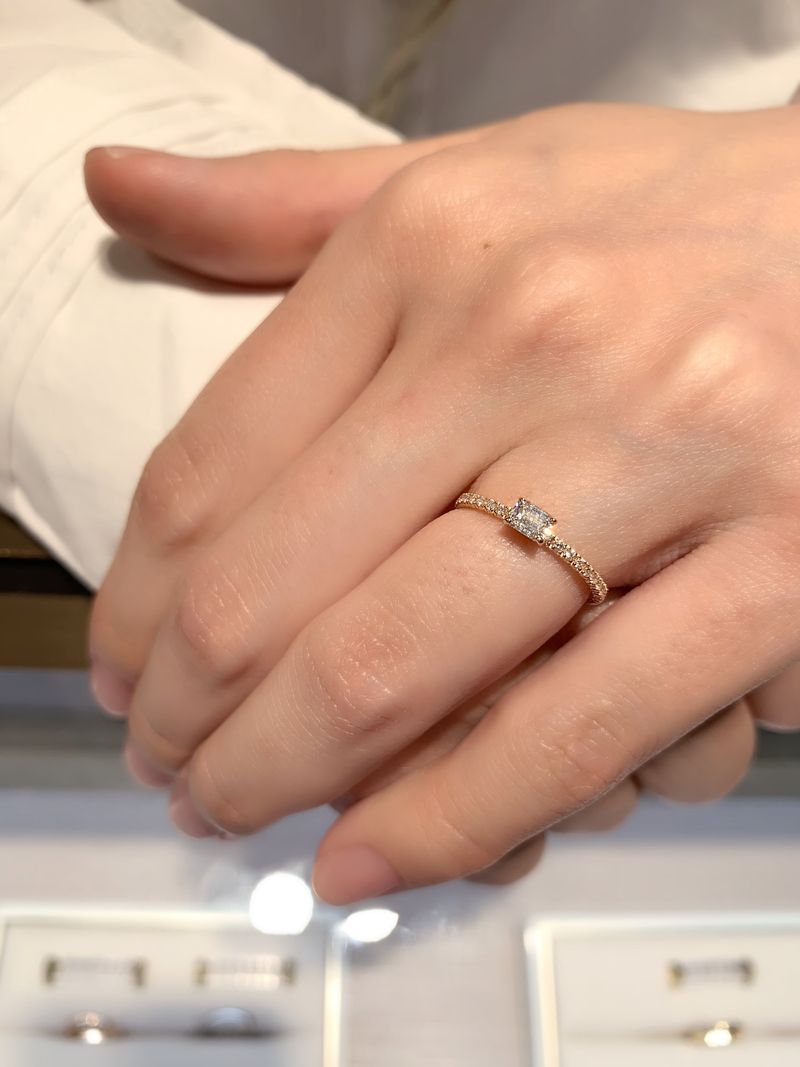 人と被らない指輪を探しており、エメラルドカットのダイヤモンドの婚約