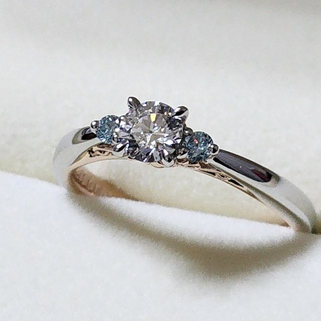 【ケイウノ ブライダル(K.UNO BRIDAL)の口コミ】 メインのダイヤモンドの両脇にブルーのメレダイヤを添えて華やかな印象に…