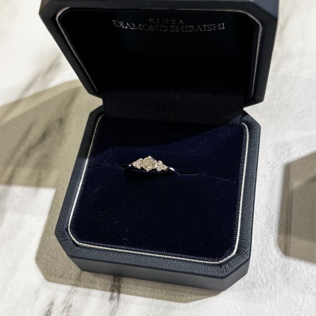 【銀座ダイヤモンドシライシの口コミ】 素材はプラチナ950です。デザインは真ん中に大きなダイヤと周りに小さいダ…