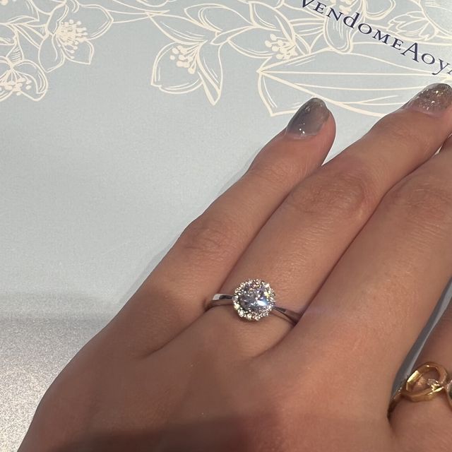 【ヴァンドーム青山(VENDOME AOYAMA)の口コミ】 大きなダイヤモンドを小さなダイヤモンドでぐるっと取り巻いたデザイン。
…