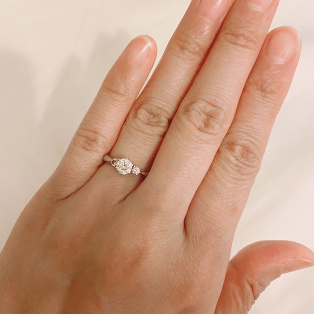 【ジュエリーツツミ(JEWELRY TSUTSUMI)の口コミ】 この指輪の決め手は、大粒のダイヤモンドの両端に色が濃い目のピンクダイ…